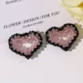 Primer plano de coleteros de cuentas con forma de corazón negro y rosa brillante, detalle. - Rosa