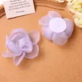 Primer plano detalle de pinza de pelo flor de malla purpura con centro de perla y reverso. - Púrpura