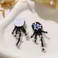 Close-up detail of black beaded fringe sequin flower DIY accessories, intricate handmade texture. - Black