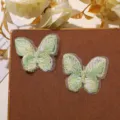Detalle de primeros planos de mariposas bordadas de encaje de doble capa verde para manualidades. - Verde