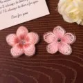Detailed close-up view of exquisite pink gradient five-petal embroidered flower patches. - Pink
