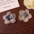 Gold and blue gradient embroidered five-petal flower patch DIY craft apparel accessory detail view. - Brown