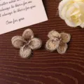Close-up detail of gold gradient five-petal embroidered flower patch for DIY clothing decor. - Brown Small