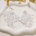 Handmade white beaded fringe flower earrings DIY apparel accessories detail shot, elegant style. - Beige