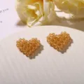 Amber crystal beaded heart DIY charm detail view showing exquisite handmade woven texture. - Coffee