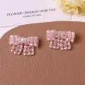 Detailed close-up of handmade pink crystal beaded bow accessories with pearls for diy crafts. - Pink