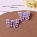 Detailed close-up of handmade purple beaded bow DIY accessories with pearl embellishment. - Purple