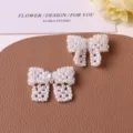Close-up detail of white pearl beaded bow DIY accessories, elegant handmade craft decoration. - Beige