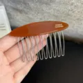 Nahaufnahme eines braunen Acetat-Haarkamms mit silbernen Zähnen für tägliches Styling. - Karamellbraun