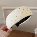 Detailed view of a white wide headband with black polka dots, soft knit fabric texture. - White Wide Polka Dot Style