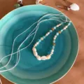 Detail shot of bohemian shell and stone braided rope jewelry, featuring natural cowrie and beads. - Style E