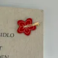 Fermaglio per capelli a fiore rosso con design a becco d'anatra dorato, ideale per acconciature. - Forcina Floreale Rossa / Clip Senza Segni