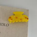 Close-up of a yellow resin hair claw clip featuring cute floral and rhinestone decorations. - Yellow Flower / M