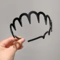 Gros plan détaillé du serre-tête noir ondulé en plastique à dents pour la coiffure quotidienne. - Style Vague / Vagues Noires