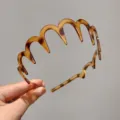 Gros plan du serre-tête ondulé effet écaille de tortue avec sa structure dentelée. - Style Onde / Vague d'ambre
