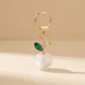 Elegant acrylic pearl apple keychain with green crystal leaf and gold clasp for bags. - White