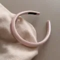 Serre-tête minimaliste en satin rose en gros plan, accessoire de cheveux élégant couleur unie. - Rose