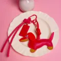Red leather dachshund dog keychain and chocolate bar bag charm with long strap accessory. - Red