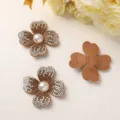 Detail view of sparkly rhinestone four-petal flower DIY accessories with pearl centers. - Champagne