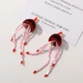 Detalle de pendientes de borla de medusa de hada dulce, joyería artesanal DIY única. - Burdeos