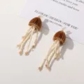 Vista detallada de pendientes colgantes de cuentas con diseño de medusa ideales para tu look. - Café