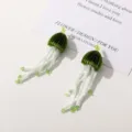Beaded jellyfish earrings detail close up green and white handmade floral tassel drop design. - Dark Green