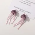 Close up detail view of handmade purple beaded jellyfish tassel earrings with cute design. - Purple