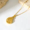 Close-up of a delicate gold-toned ammonite pendant necklace on white surface with stone prop. - Ammonite Conch Pendant (N241) / N241