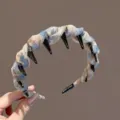 Detail view of a chic patterned fabric headband with anti-slip teeth and handmade label. - Blue