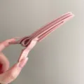 Close-up detail shot showing the pink plastic duckbill hair root volumizing clip design. - Pink
