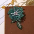 Gros plan détaillé d'un patch de fleur brodé de fil vert avec centre de perles de cristal - Vert Lac
