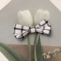 Detalle de accesorio para cabello con lazo de tela a cuadros en blanco y negro, horquilla elegante. - S / Negro