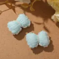Primer plano de lazos de perlas tejidos en azul claro, perfectos para accesorios. - Verde