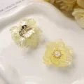 Close-up detail of AB color acrylic flower petals and pearl DIY hair accessory parts. - Yellow