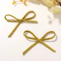 Scatto di dettaglio di accessori con fiocchi in velluto scamosciato giallo senape retrò per fai da te. - Giallo Senape