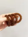 Detailopname van doorschijnende bruine spiraalhaarbanden met hoge elasticiteit en glans. - Jelly donker koffiebruin