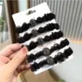 Primo piano dettagliato di elastici per capelli in organza nera con perle di strass scintillanti. - 1 Elastico per capelli in organza nera