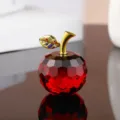 Detailed view of red crystal apple ornament showing faceted cut and gold leaf with colorful stones. - Red