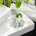 Close-up detail of clear crystal glass pumpkin figurine with green stem, elegant desk ornament. - Clear