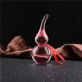 Gros plan d'un ornement de gourde en verre cristal rose avec un ruban rouge délicat et élégant. - 9.5cm de Haut / Rose