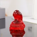 Close up of red crystal zodiac snake figurine detail, sleek glass texture for home decor. - Red