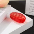 Detailed close-up of a red crystal glass corn figurine ornament on a white display block. - 65mm Corn Decor / Red