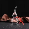 Vue détaillée d'un ornement de gourde en cristal transparent avec ruban rouge, décor chic. - 9.5cm de Haut / Transparent