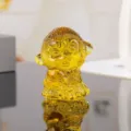 Close-up detail shot of yellow crystal monkey figurine holding peach, exquisite craftsmanship. - 5cm Height / Yellow