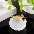 Detailed view of a crystal glass pumpkin figurine with elegant gold floral branch decoration. - Frosted Effect