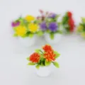 Detailaufnahme einer Puppenhaus-Topfpflanze, künstliche orange Blumen in einem kleinen Topf. - Orange