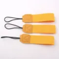 Detailed view of portable yellow cup lanyard with leather stitching and black hanging loop. - Yellow
