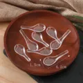 Detailansicht von transparenten Mini-Plastiklöffeln, Puppenhaus-Geschirr und Food-Play-Zubehör. - 4 cm transparenter Löffel