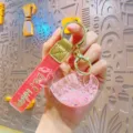 Cute pink liquid whale keychain with glitter quicksand design, metal ring and strap. - Pink