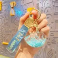 Cute blue whale liquid quicksand keychain with blue strap and gold hardware accessories. - Blue